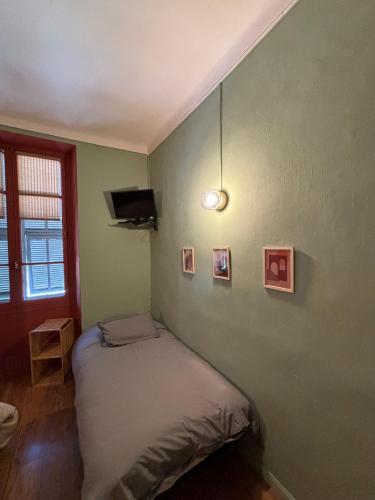 a bedroom with a bed and a wall with pictures at Hôtel Fleur des Alpes in La Brigue