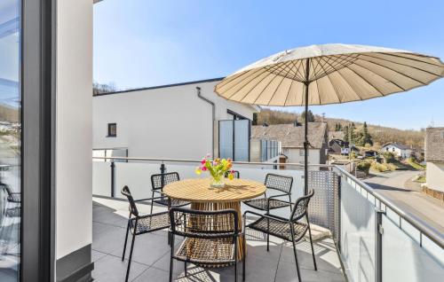 a balcony with a table and chairs and an umbrella at 3 Bedroom Lovely Home In Kirchen - Sieg in Offhausen