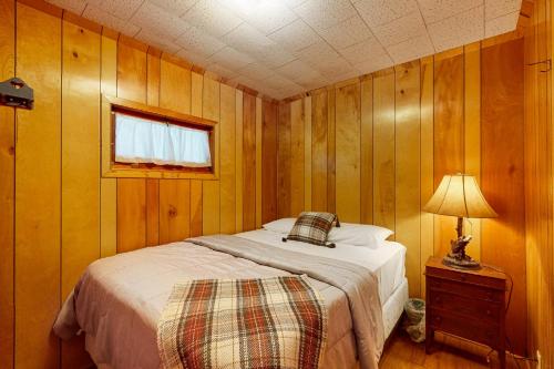 a bedroom with a bed and a lamp and a window at Timberlane Lodge- The Musky, Bluegill & Walleye in Woodruff