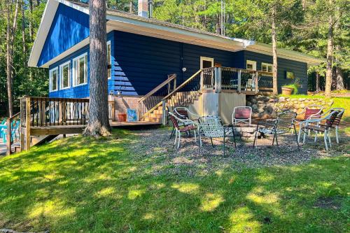 a house with chairs and a porch with a tree at Timberlane Lodge- The Musky, Bluegill & Walleye in Woodruff