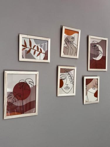 a group of framed pictures on a wall at Hôtel Fleur des Alpes in La Brigue