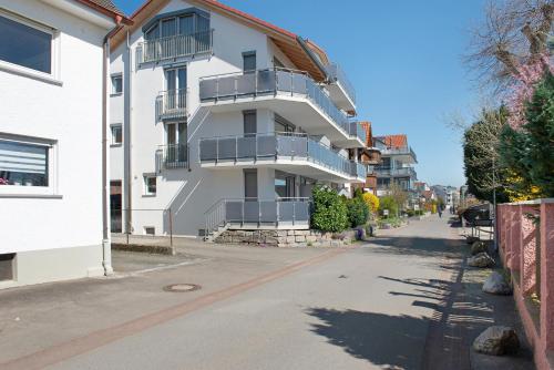 a white building with balconies on the side of a street at Gästehaus D i c k r e i t e r in Immenstaad am Bodensee
