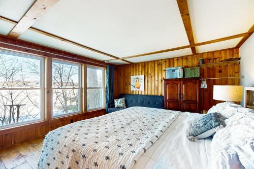 a bedroom with a large bed and windows at 144 Heritage Woods Lane in Winthrop