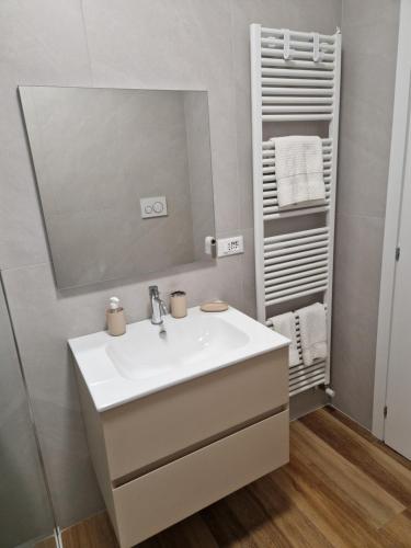 Un baño con un lavabo blanco y un espejo. en Cà del Luis, en Lierna