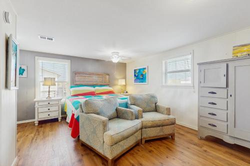 a bedroom with a bed and a chair at Macs Fish Camp in Dauphin Island
