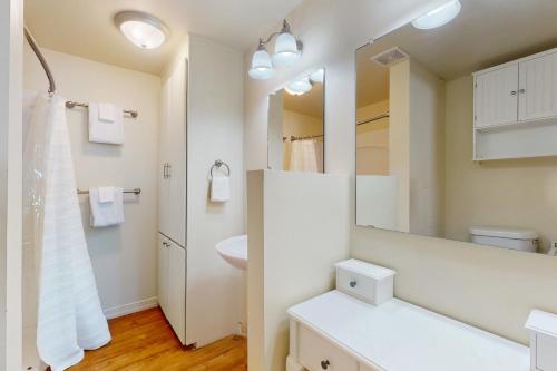 a white bathroom with a sink and a mirror at Macs Fish Camp in Dauphin Island