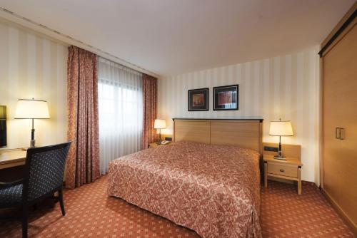 a hotel room with a bed and a desk at Maritim Hotel Dresden in Dresden