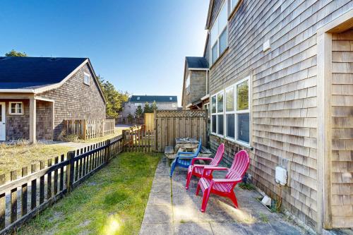 three chairs and a table on the side of a house at Seas the Day in Shorepine in Pacific City