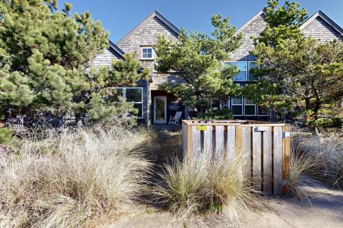 a house with a fence in front of it at Seas the Day in Shorepine in Pacific City