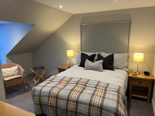 a bedroom with a bed with pillows and two lamps at Balnain Street Cottage in Inverness