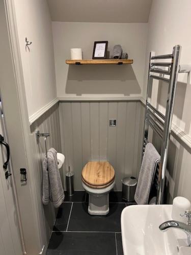 a bathroom with a wooden toilet and a sink at Balnain Street Cottage in Inverness