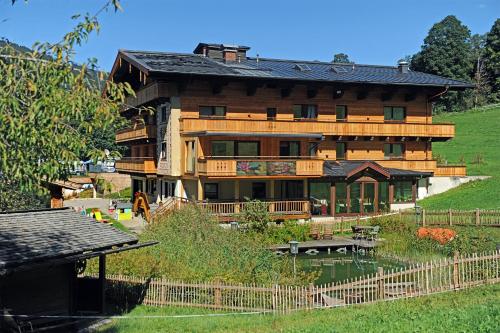 a large wooden house on top of a hill at Ski in Ski out Hotel Unterellmau inkl Jokercard in Saalbach-Hinterglemm