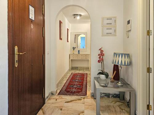 a hallway with a door and a table and a rug at Two bedroom apartment with pool & sea views in Mijas Costa