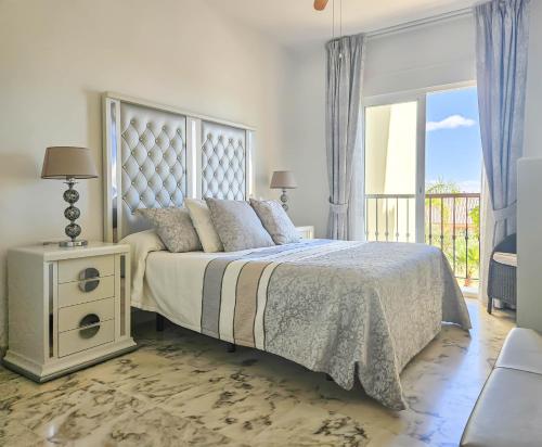 a bedroom with a large bed and a balcony at Two bedroom apartment with pool & sea views in Mijas Costa