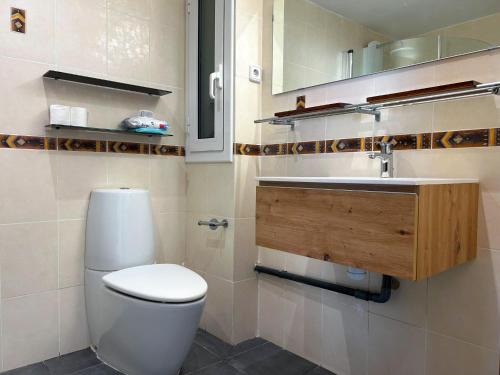 a bathroom with a white toilet and a sink at PalmBreeze in Vilanova i la Geltrú