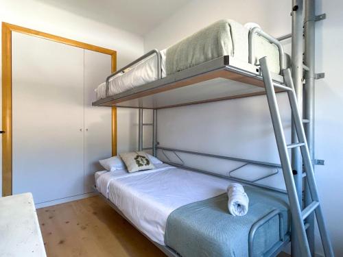 a bedroom with two bunk beds and a ladder at PalmBreeze in Vilanova i la Geltrú