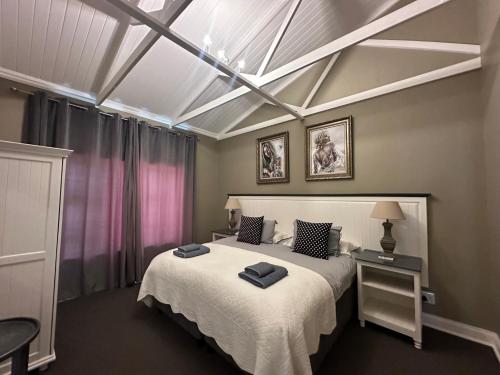 a bedroom with a large bed with a skylight at Clarens Old Clubhouse in Clarens