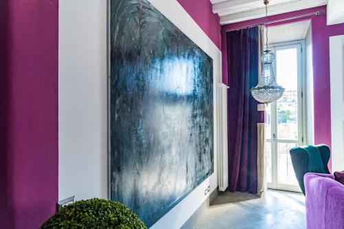 a living room with purple walls and a large painting at Luxury House FV in Formello