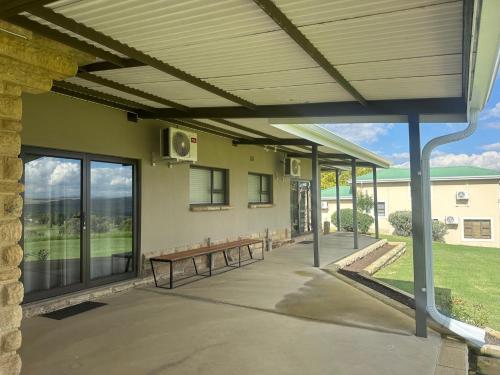 a covered patio with benches in front of a building at Clarens Old Clubhouse in Clarens