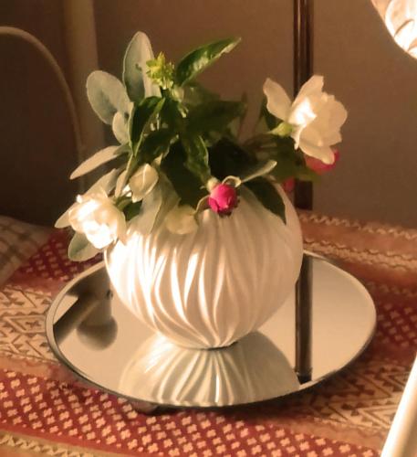 a white vase with flowers on a plate on a table at Studniska Country Estate in Studniska