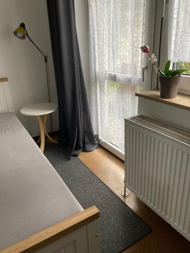 a bedroom with a bed and a window with a table at Appartements an der Kaiserpfalz - Königshof in Forchheim