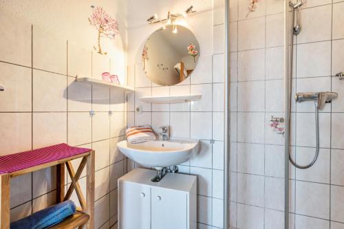 a bathroom with a sink and a shower at Hus Tingeltut Gerd Clausen in Pellworm