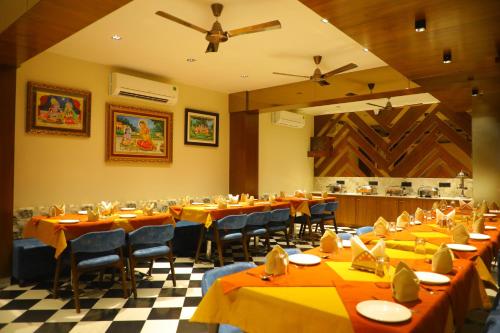 a restaurant with tables and chairs and a ceiling fan at The Sky Imperial Hotel Sugam - 10 Meters from Shrinathji Temple in Nāthdwāra
