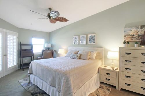 a bedroom with a large bed with a dresser and a dresser at 2nd floor bayfront Siesta Key condo with private beach access in Siesta Key