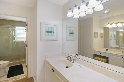 a bathroom with a sink and a large mirror at 2nd floor bayfront Siesta Key condo with private beach access in Siesta Key