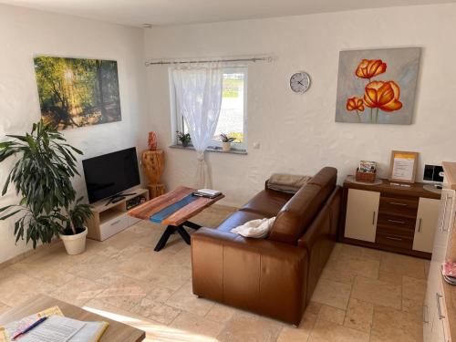 a living room with a couch and a table at 4 Sterne Ferienwohnung Stammzeit in Nettersheim