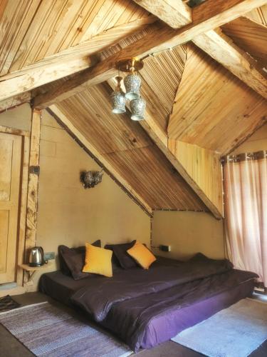 a large bed in a room with wooden ceilings at YAARI Shangarh in Shangarh