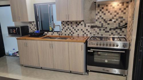 a kitchen with a stove and a sink at A Modern EscapeStyle Comfort and Convenience 3 bedroom in Maraval
