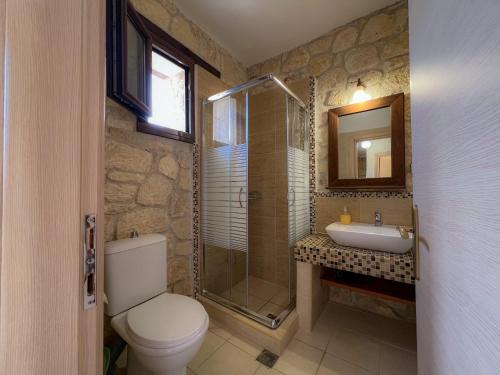 a bathroom with a toilet and a sink and a shower at Artis Stone Heaven Retreat in Kalandra