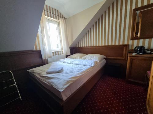 a small bed in a room with a window at Pałac Lucja BB in Zakrzów
