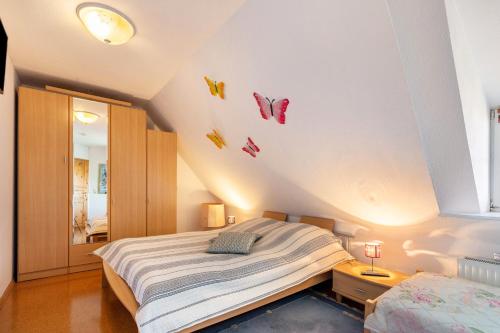 a bedroom with a bed and a window with butterflies on the wall at Hus Tingeltut Gerd Clausen in Pellworm