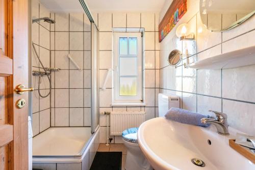 a bathroom with a sink and a toilet and a shower at Hus Tingeltut Gerd Clausen in Pellworm