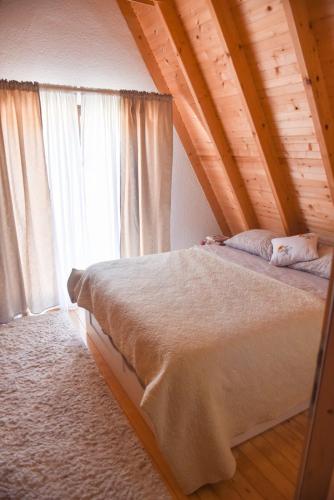 a bedroom with a large bed with a wooden ceiling at Sara in Malo Polje