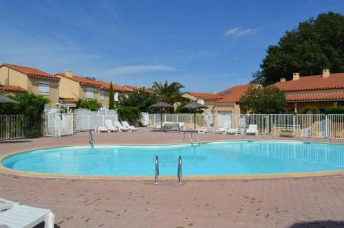 une grande piscine bleue dans une cour dans l'établissement Maison 2 pièces mezzanine 5 couchages ARGELES SUR MER AR100-033, à Argelès-sur-Mer