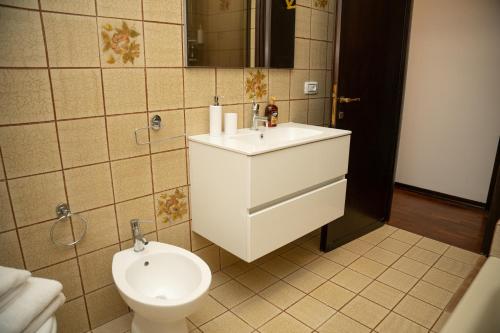 a bathroom with a white sink and a toilet at Villa Baraggioli in Galliate
