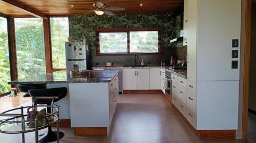 a kitchen with white cabinets and a black counter top at Corcovado Accommodations-pool-best views-nature in Puerto Jiménez