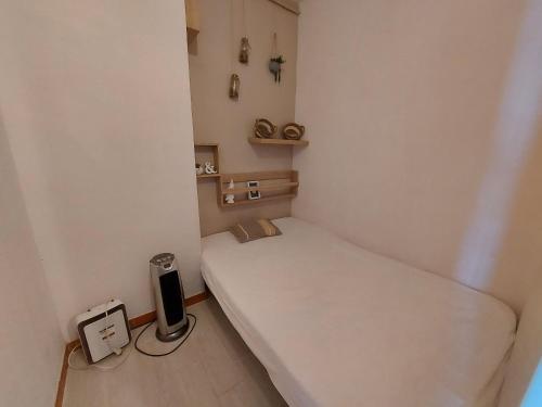 Cette petite chambre comprend un lit blanc. dans l'établissement Studio cabine rénové à 500m des plages, terrasse, animaux admis - FR-1-776-131, à Argelès-sur-Mer