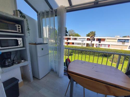d'un balcon avec une table et une vue sur un bâtiment. dans l'établissement Studio cabine rénové à 500m des plages, terrasse, animaux admis - FR-1-776-131, à Argelès-sur-Mer