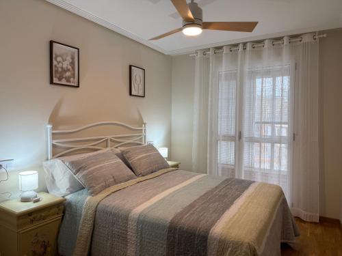 a bedroom with a bed and a ceiling fan at BierzINN Apartamentos - Martina in Ponferrada