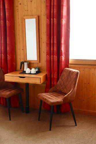 a table and two chairs and a mirror on a table at Hôtel Val Chavière in Val Thorens