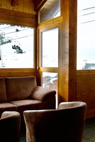 a room with a chair and a person on a ski lift at Hôtel Val Chavière in Val Thorens