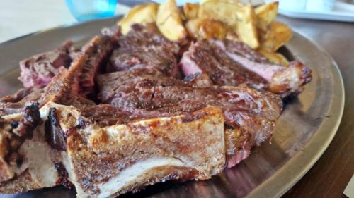 a plate of food with meat and french fries at agriturismo macchia al pino in Pomaia