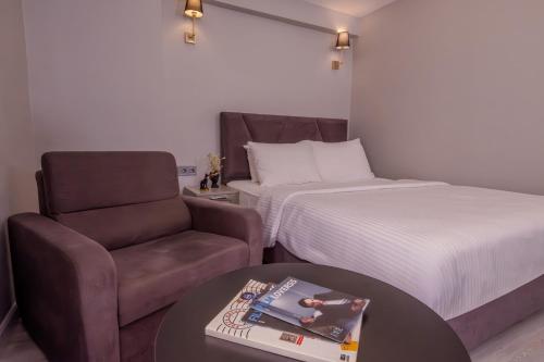 a bedroom with a bed and a chair and a table at Rubby Kadıköy in Istanbul