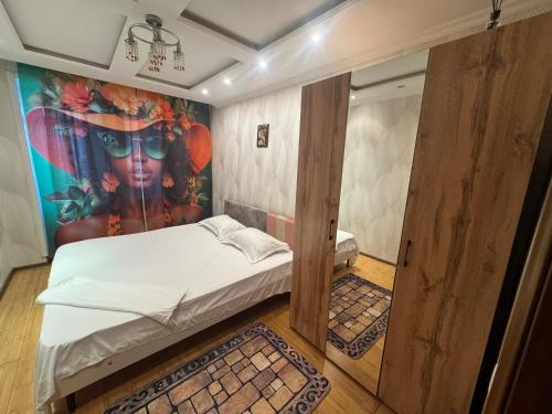 een kamer met een bed en een schilderij aan de muur bij Ермекова 52 in Karagandy