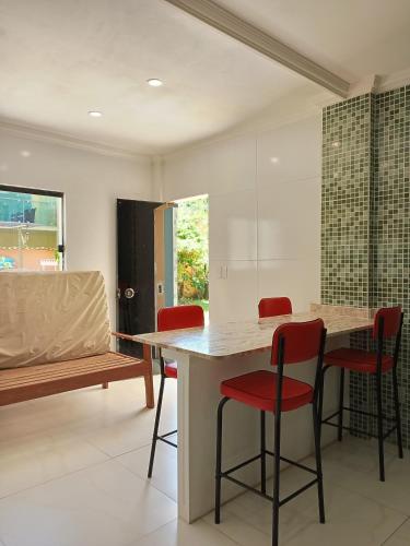 a kitchen with a table and four red chairs at Ilhéus praia in Ilhéus