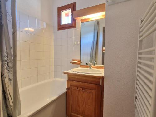 une salle de bain avec un lavabo, une baignoire et un miroir dans l'établissement Appartement 3 pièces pour 4/6 pers à Valfréjus avec balcon - FR-1-265-181, à Valfréjus